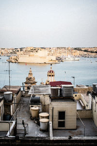 High angle view of buildings by sea against clear sky