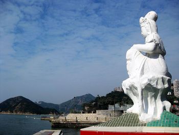 Statue by mountain against sky
