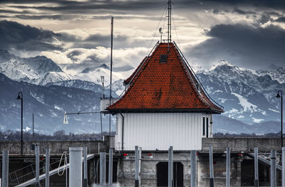 Traditional windmill on snowcapped mountain against sky