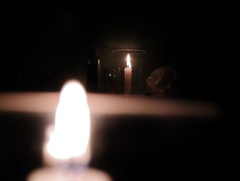 Close-up of lit candle in darkroom