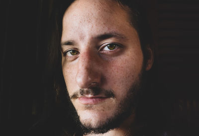 Close-up portrait of young man in darkroom