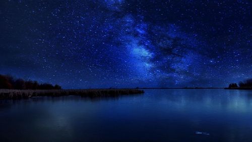 Scenic view of lake against star field at night