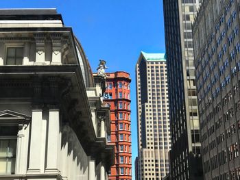 Low angle view of buildings against clear blue sky