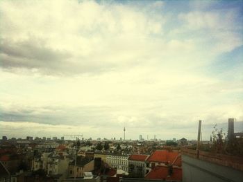 View of cityscape against cloudy sky