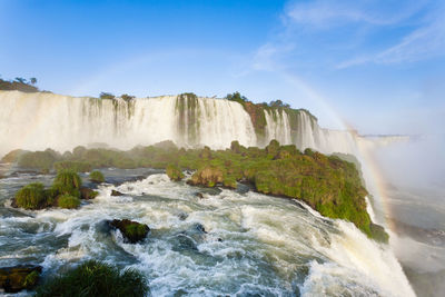 Scenic view of waterfall against sky