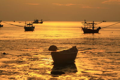 Silhouette boat in sea against sky during sunset