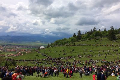 People on field against cloudy sky