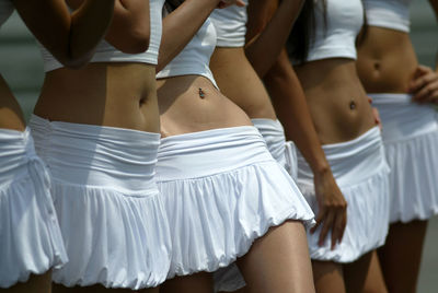 Midsection of women in mini skirts during event
