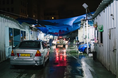 Wet street amidst buildings in city during rainy season