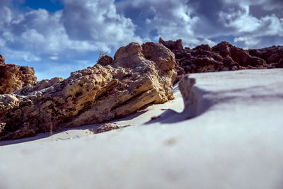 Snow on rock against sky