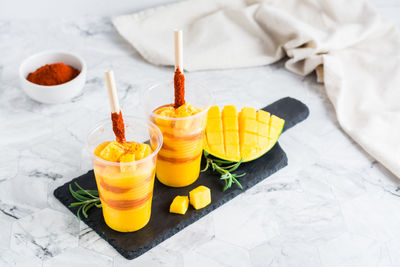 Mangonada mexican smoothie from mango with chamoy sauce and tamarind straw in plastic glasses