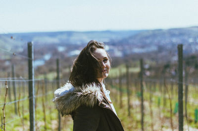 Portrait of young woman standing on land against sky