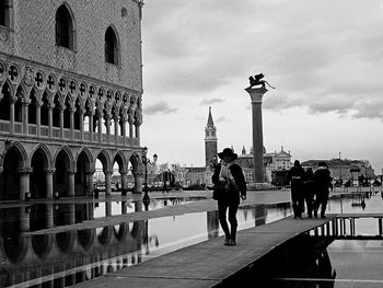 People in city against cloudy sky