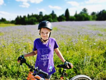 Portrait of smiling boy riding bicycle on field