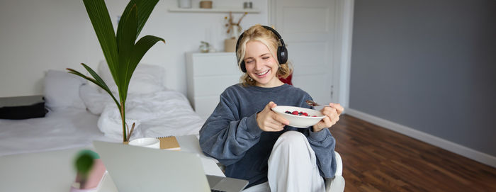 Portrait of young woman using digital tablet at home