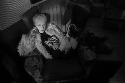 High angle portrait of young woman on sofa at home