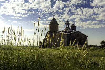 Built structure on field against sky