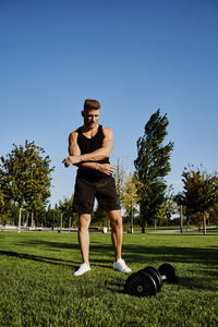 Full length of man with arms raised against sky