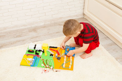 High angle view of boy playing with toy on floor