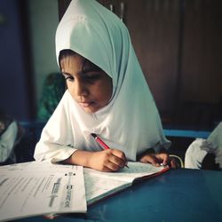 Close-up of girl wearing hijab while studying