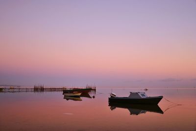 Sailboats in sea against sky during sunset