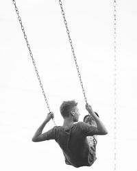 Rear view of man on swing at playground