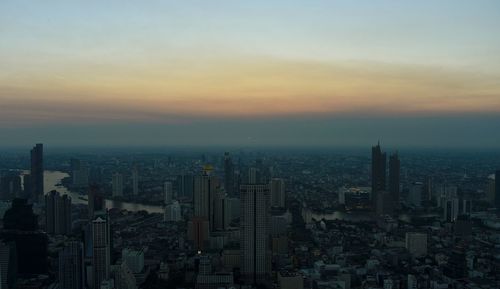 Aerial view of buildings in city during sunset