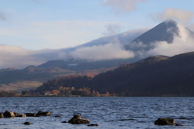 Scenic view of sea and mountains against sky