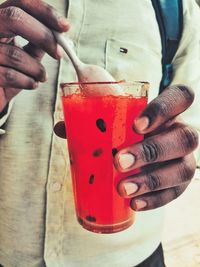 Midsection of man holding red wine