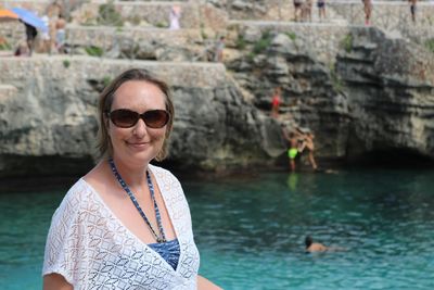 Portrait of woman wearing sunglasses against sea