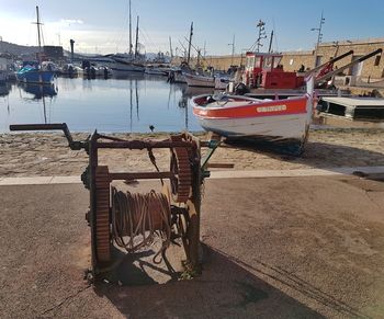 Boats moored at harbor against sky