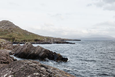 Scenic view of sea and mountains against sky