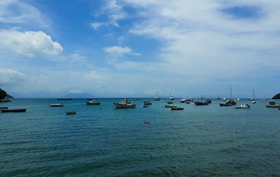 Sailboats in sea against sky