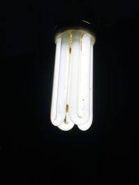 Low angle view of illuminated light bulb against black background