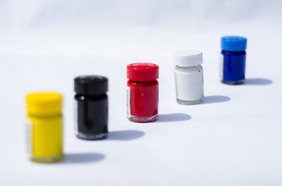 Close-up of multi colored bottles against white background