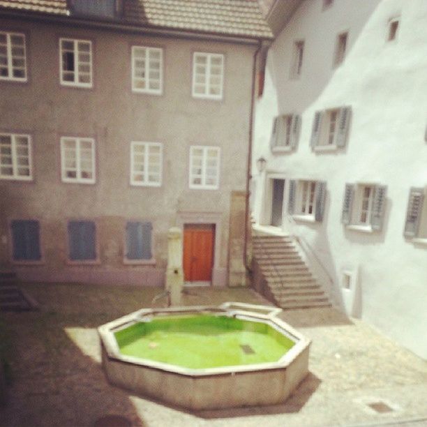 architecture, building exterior, built structure, window, building, residential building, residential structure, house, day, city, no people, table, outdoors, absence, sunlight, potted plant, green color, empty, shadow, high angle view