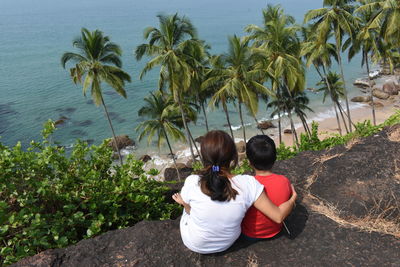 Rear view of people on palm trees by plants