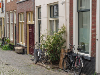 Bicycles by footpath against building