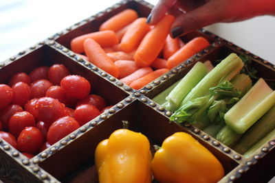 Cropped image of woman holding container with various vegetables