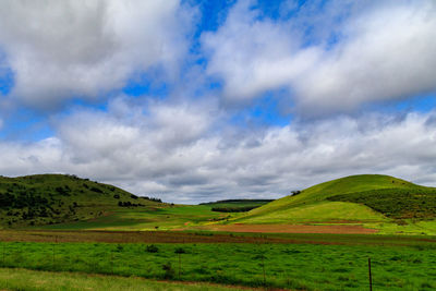 Scenic view of green landscape against sky