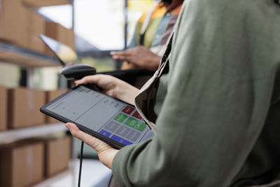 Midsection of woman using digital tablet