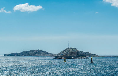 Distant view of chateau dif amidst mediterranean sea against blue sky