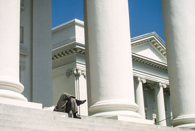 Low section of man relaxing on steps at historic building