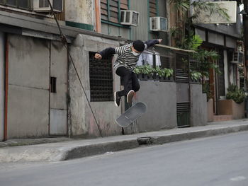 Full length of man skateboarding in city