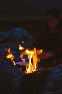 Girl in front of a campfire thinking