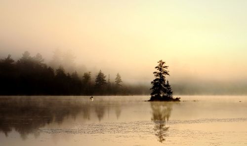 Scenic view of lake against sky during sunrise 