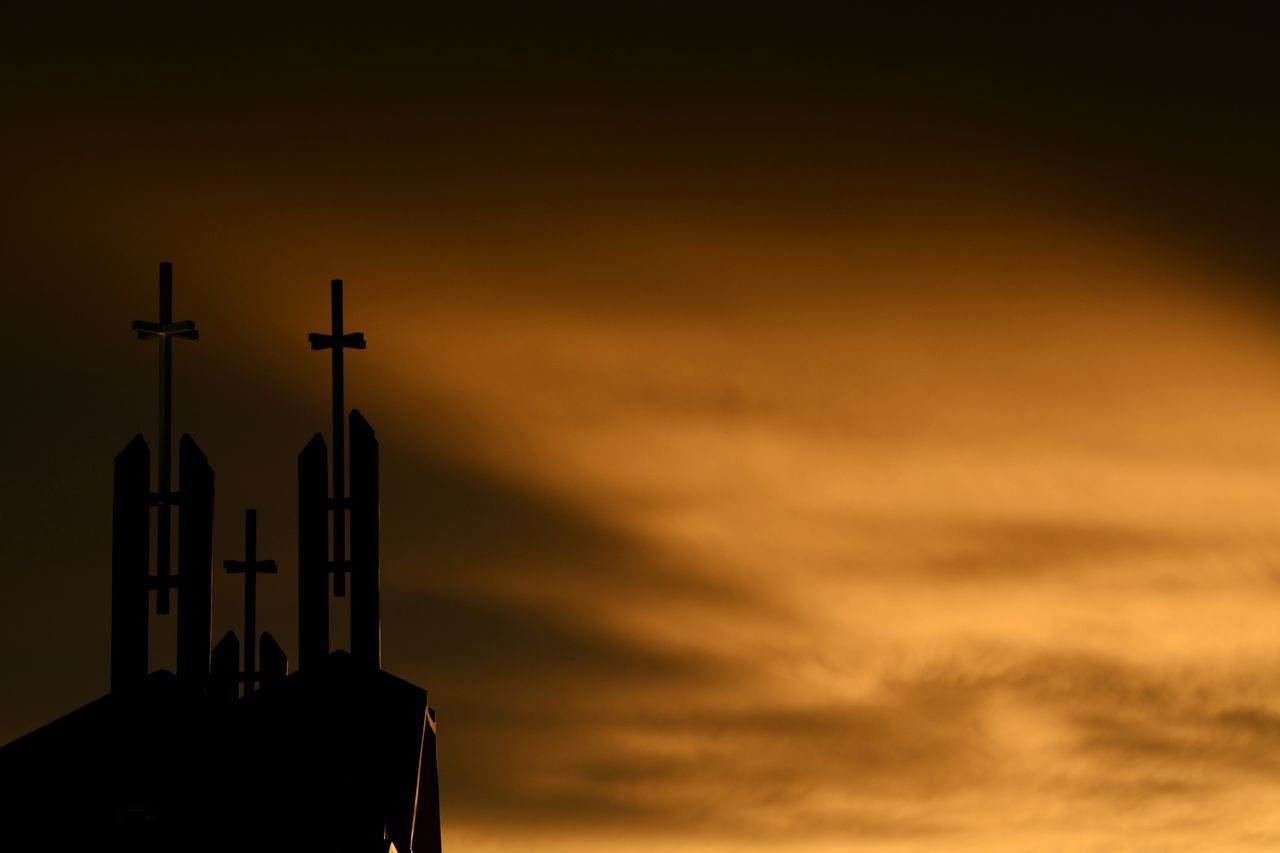 LOW ANGLE VIEW OF TOWER AT SUNSET