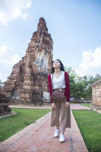 Full length of happy young woman standing in temple