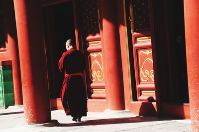 Full length rear view of woman walking in building