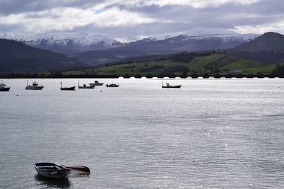 Scenic view of lake by snowcapped mountains against sky